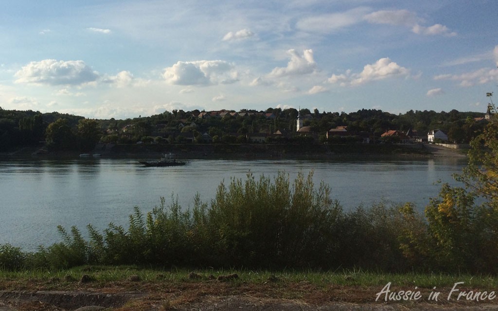 The ferry is close to the opposite bank, in the middle of the photo