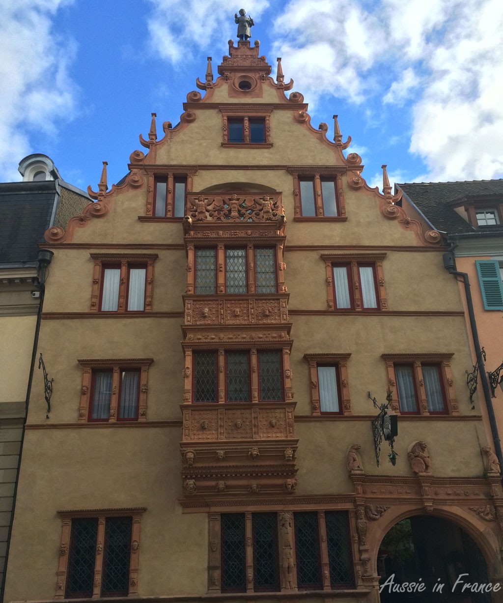 Built in 1609, La Maison des Têtes (House of Heads) owes its name to the large number of masks and grimacing faces which decorate the façade. The magnificently sculpted oriel rises to three levels. The statue of hte Alsace barrel maker was placed at the top of the gable when the building was used as a wine exchange.