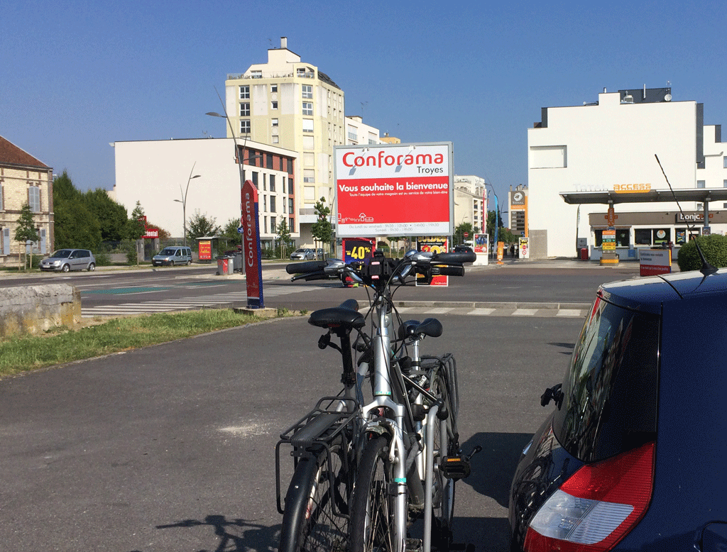 The parking lot in front of Conforama with our hotel on the right (white building)