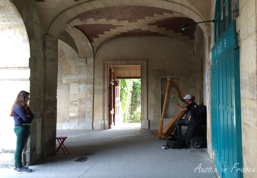 Harpist in the arcade leading onto the Hôtel de Sully on Place des Vosges