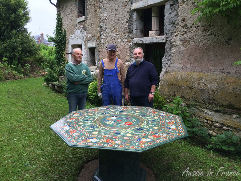 Our marble-inlay table iinstalled n its final position in the garden with the help of our neigjbour Alain and Mr Previous Owner