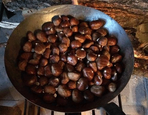 Des marrons dans une poêle à châtaignes