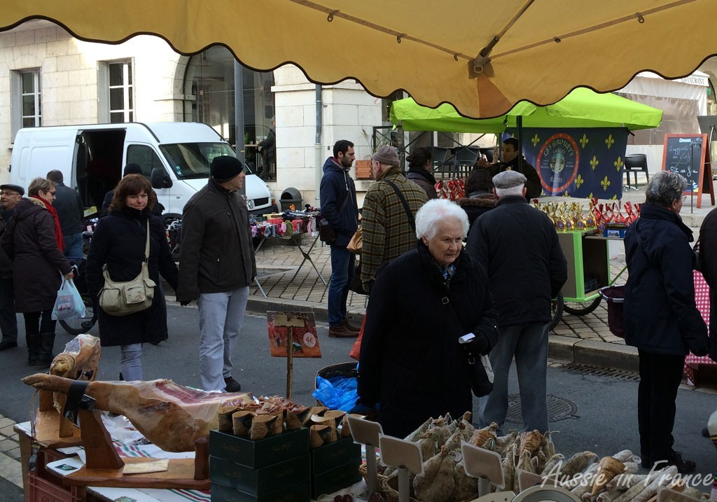 Il y avait beaucoup de monde au marché. Il y avait plusieurs personnes habillées en noir. Les gens avaient l'air content parce qu'il faisait soleil.