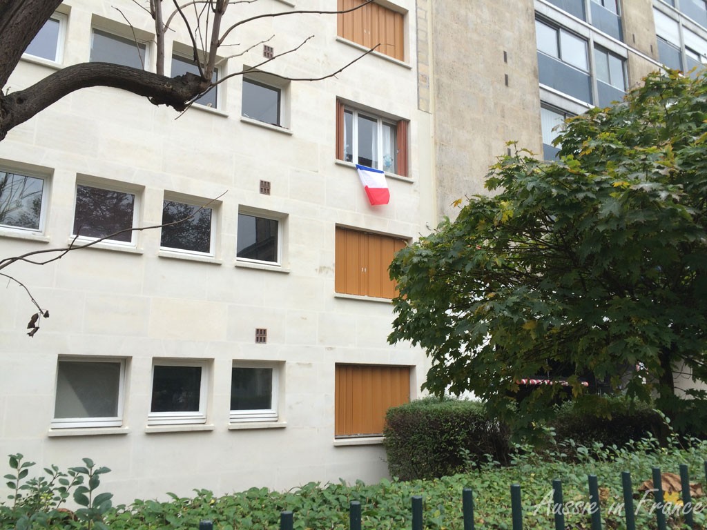 A remembrance flag on a window in the 20th arrondissement