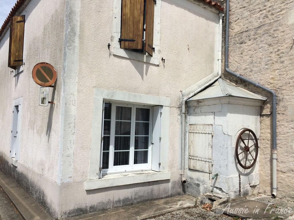 A pump room built on to a house with the wheel outside