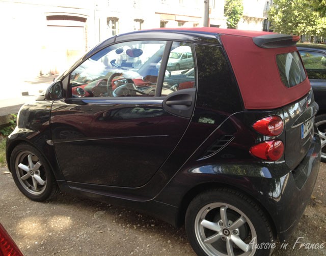 A snazzy red and black Smart car