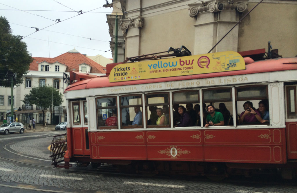 The famous n° 28 tram full of people hanging out the windows
