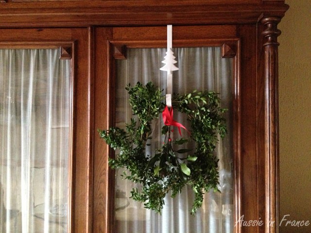Wreath made of boxwood and holly from the garden hanging on our Henri II bookcase for which I recently made curtains.